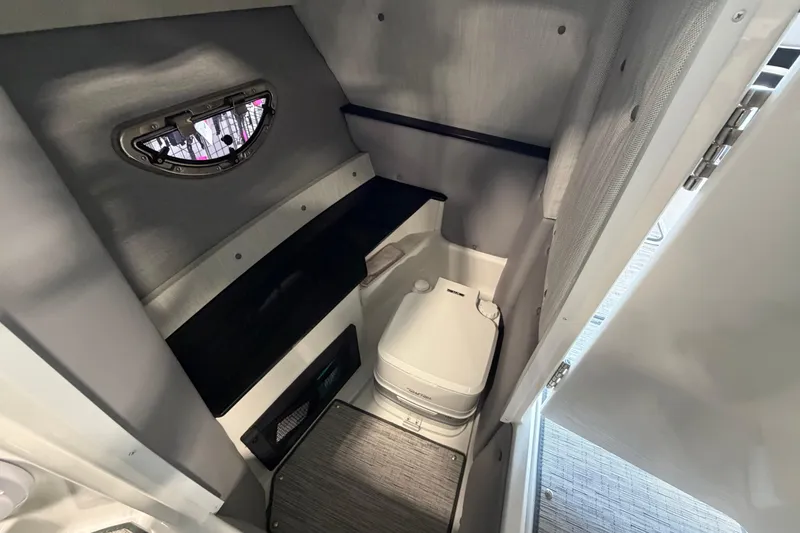 Slide: The Image of 2022 Cobalt R6 Surf boat interior with compact marine toilet and window. - 20