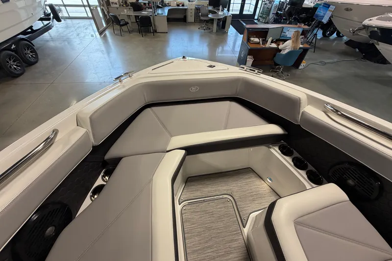 Slide: The Image of 2022 Cobalt R6 Surf boat interior with gray seating and cup holders in showroom. - 22