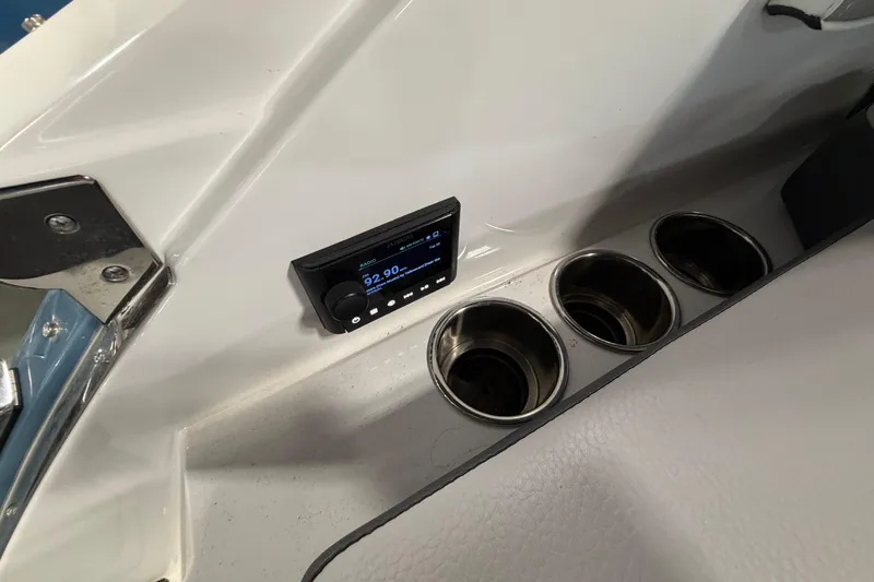 Slide: The Image of 2022 Cobalt R6 Surf boat interior with radio and cup holders. - 25