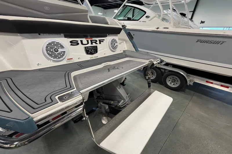 Slide: The Image of 2022 Cobalt R6 Surf boat with swim platform and speakers in showroom. - 8