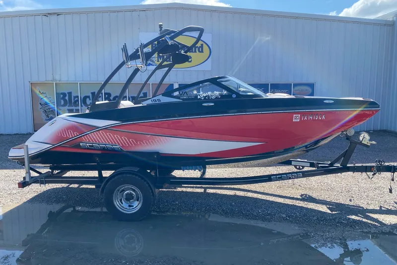 The Image of 2014 Scarab 195 H.O. Impulse boat on trailer, red and white design, parked outdoors. - 1