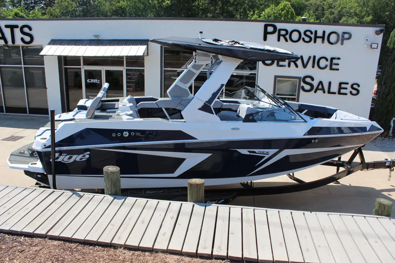 Slide: The Image of 2026 Tigé 22RZX boat displayed at a dealership, showcasing sleek design and modern features. - 2