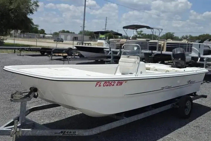The Image of 2017 Mako Pro Skiff 21 CC boat on trailer, parked outdoors under a cloudy sky. - 1