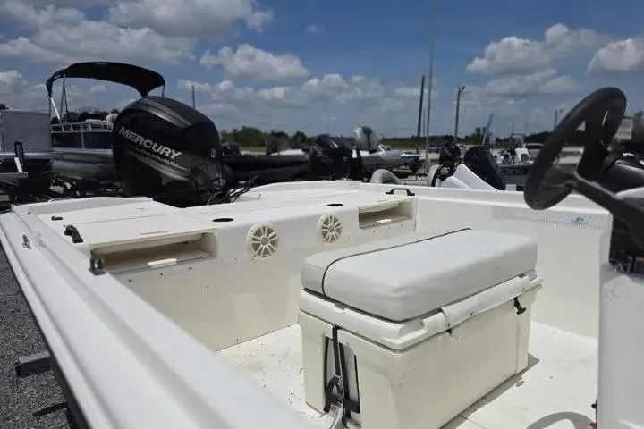 Slide: The Image of 2017 Mako Pro Skiff 21 CC boat interior with Mercury engine under a cloudy sky. - 12