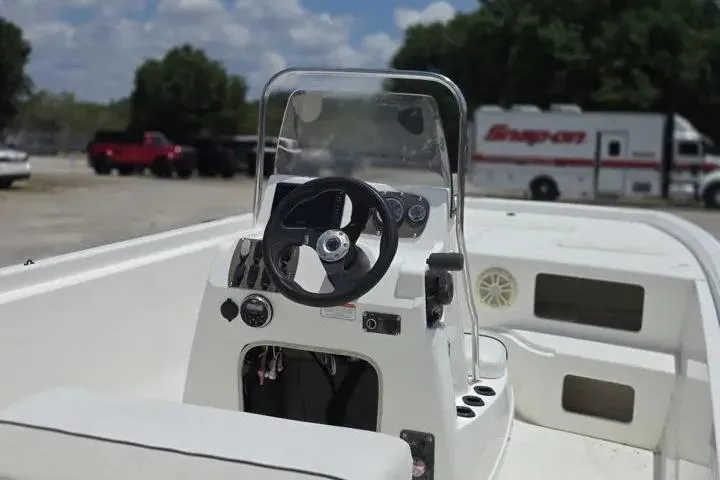 Slide: The Image of 2017 Mako Pro Skiff 21 CC boat interior with steering console and clear windshield. - 14