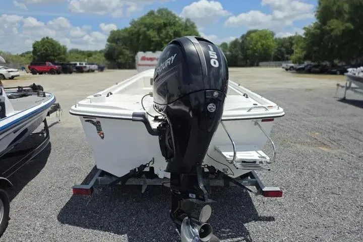 Slide: The Image of 2017 Mako Pro Skiff 21 CC boat with Mercury outboard motor on trailer, parked outdoors. - 4