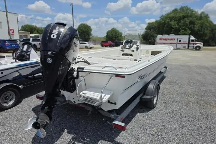 Slide: The Image of 2017 Mako Pro Skiff 21 CC boat on trailer with outboard motor in parking lot. - 5