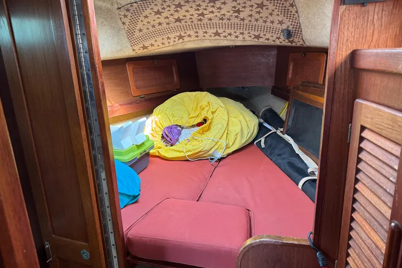 Slide: The Image of Cozy cabin interior of 1981 S2 36 sailboat with red cushions and storage items. - 12