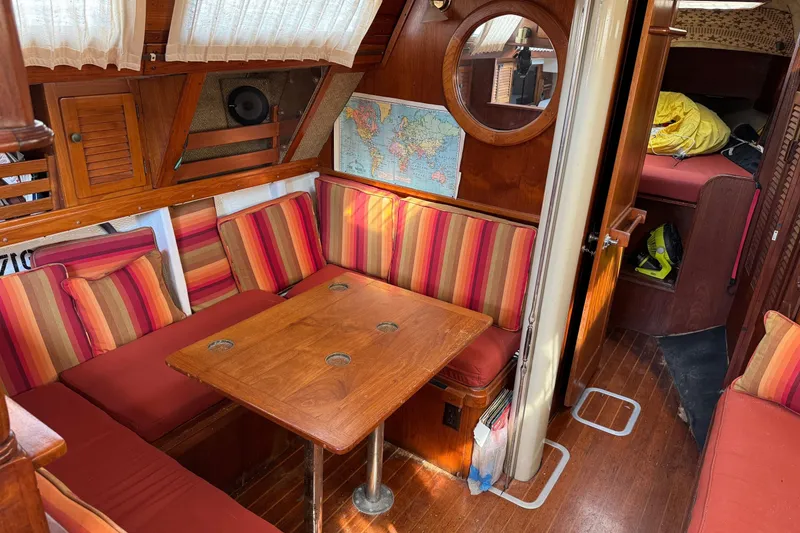 Slide: The Image of Cozy 1981 S2 36 sailboat interior with striped cushions and wooden table. - 16