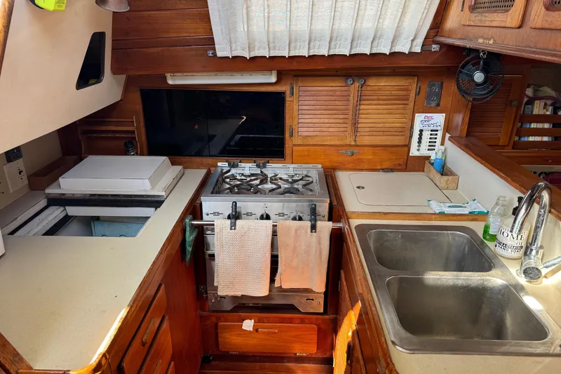 Slide: The Image of 1981 S2 36 sailboat galley with stove, sink, and wooden cabinetry. - 17