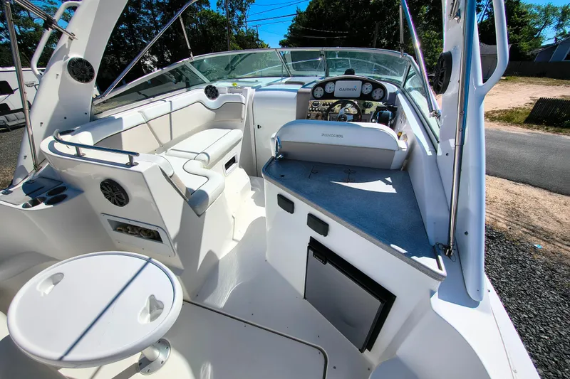 Slide: The Image of 2006 Rinker 300 Express Cruiser cockpit with seating, helm, and table in bright sunlight. - 10
