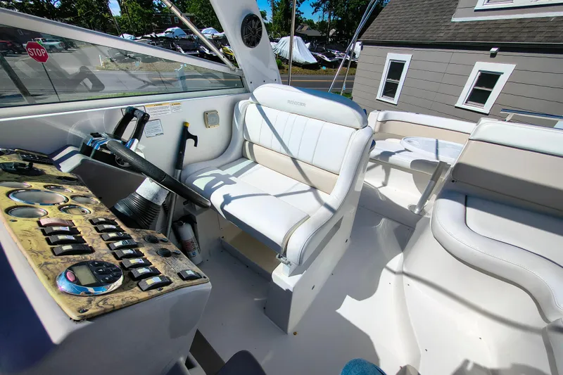 Slide: The Image of 2006 Rinker 300 Express Cruiser cockpit with steering wheel and white seating. - 12