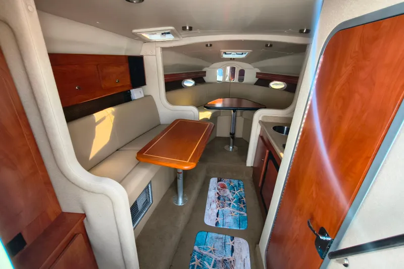 Slide: The Image of Interior of 2006 Rinker 300 Express Cruiser with seating, table, and wood accents. - 15