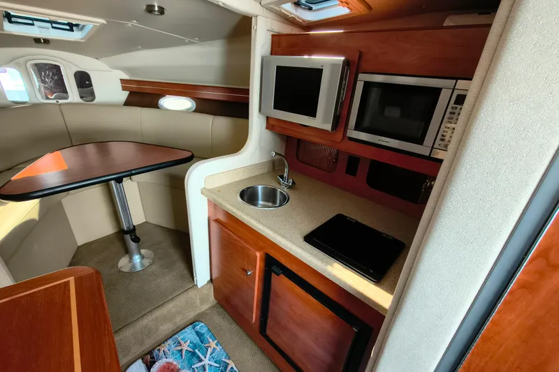 Slide: The Image of 2006 Rinker 300 Express Cruiser interior with kitchenette and dining area. - 18