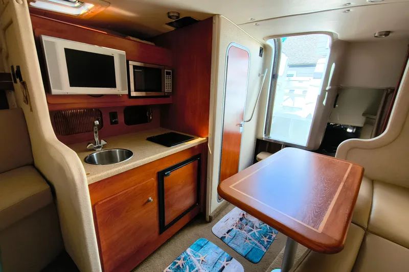 Slide: The Image of 2006 Rinker 300 Express Cruiser interior with kitchenette and dining area. - 19