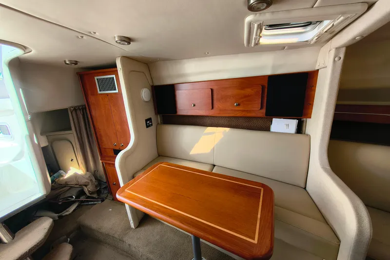 Slide: The Image of Interior of 2006 Rinker 300 Express Cruiser with wooden table and seating area. - 20