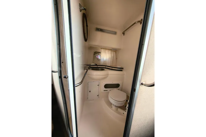 Slide: The Image of 2006 Rinker 300 Express Cruiser bathroom interior with toilet and sink. - 22