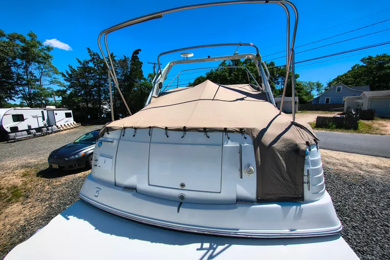 Slide: The Image of 2006 Rinker 300 Express Cruiser covered, parked outdoors on a sunny day. - 24