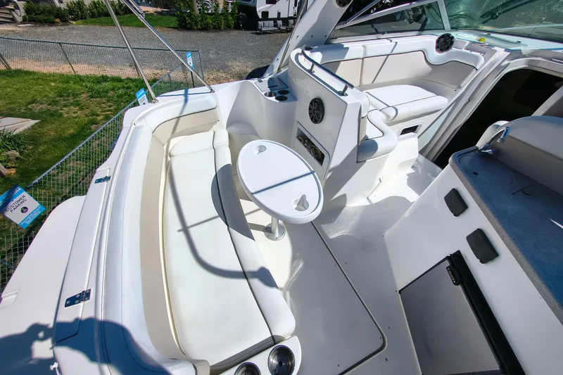 Slide: The Image of 2006 Rinker 300 Express Cruiser interior with white seating and table, showcasing luxury design. - 9
