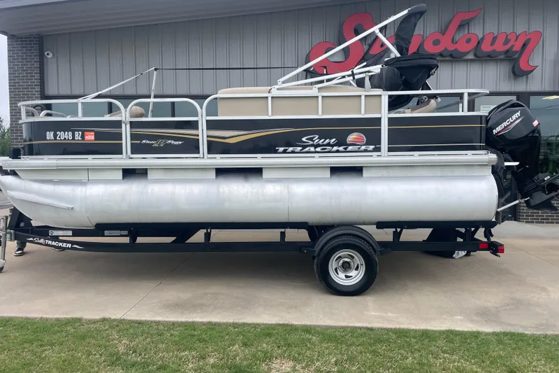 The Image of 2021 Sun Tracker Bass Buggy 18 DLX pontoon boat on trailer, parked outdoors. - 0