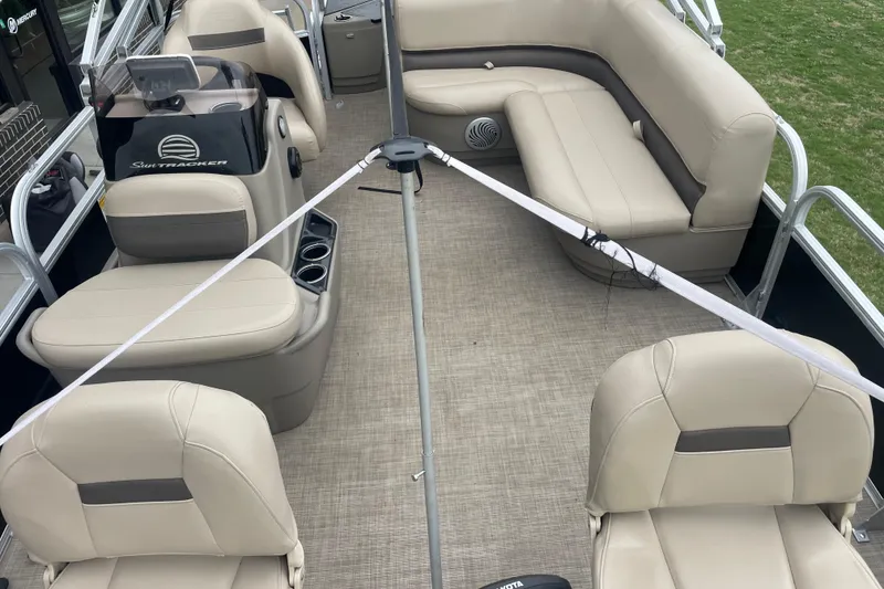 Slide: The Image of 2021 Sun Tracker Bass Buggy 18 DLX pontoon boat interior with beige seating and steering console. - 6