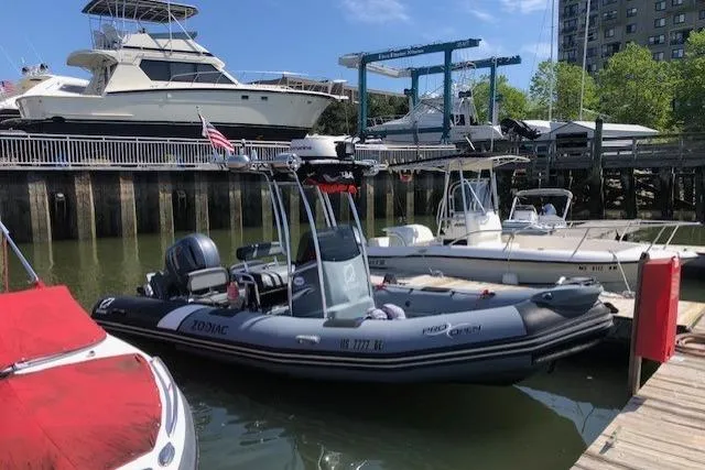 The Image of 2018 Zodiac Pro Open 650 boat docked in a marina with other vessels. - 1