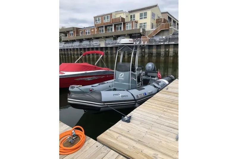 Slide: The Image of 2018 Zodiac Pro Open 650 boat docked at marina with residential backdrop. - 5