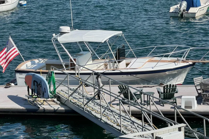 The Image of 1986 Dusky 26 Custom boat docked with American flag, surrounded by calm water. - 0