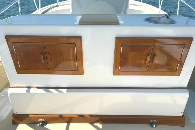 Slide: The Image of 1986 Dusky 26 Custom boat interior with wooden cabinets and sink. - 15