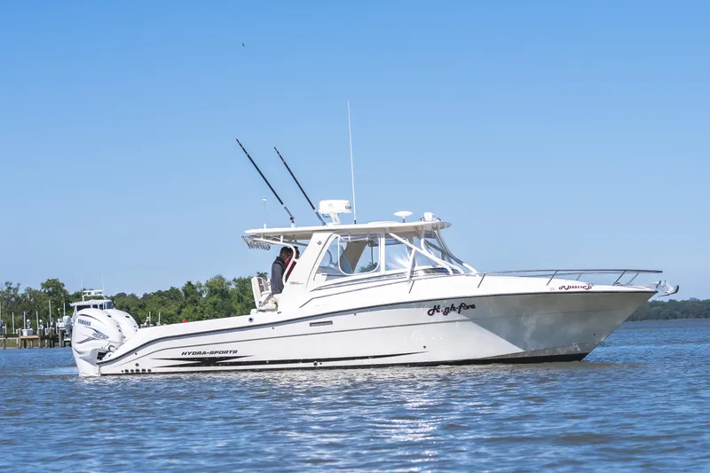 Slide: The Image of 2008 Hydrosport 3500 VX boat cruising on a calm lake under clear blue skies. - 2