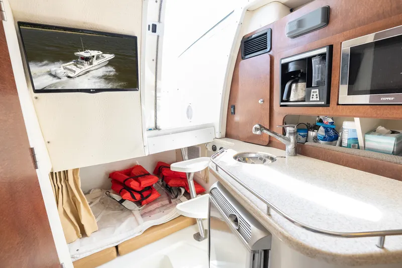 Slide: The Image of Interior of 2008 Hydrosport 3500 VX boat with kitchenette and safety equipment. - 25