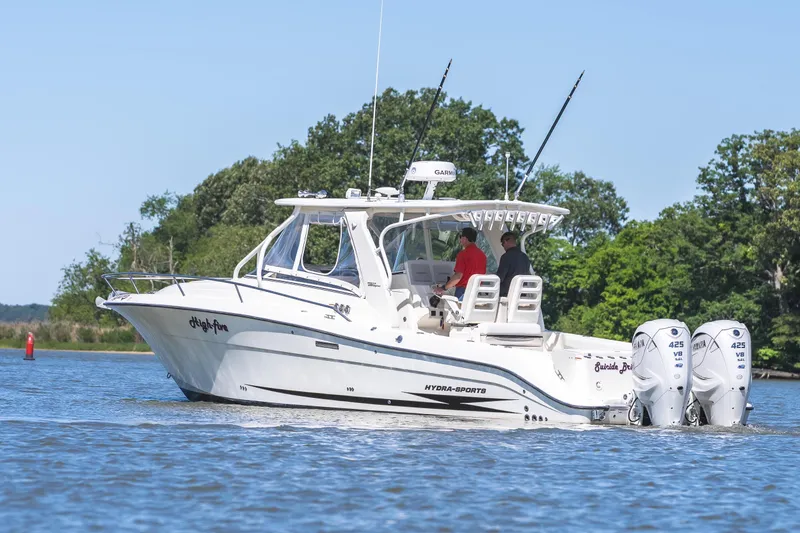Slide: The Image of 2008 Hydrosport 3500 VX boat cruising on a calm lake with lush greenery. - 3