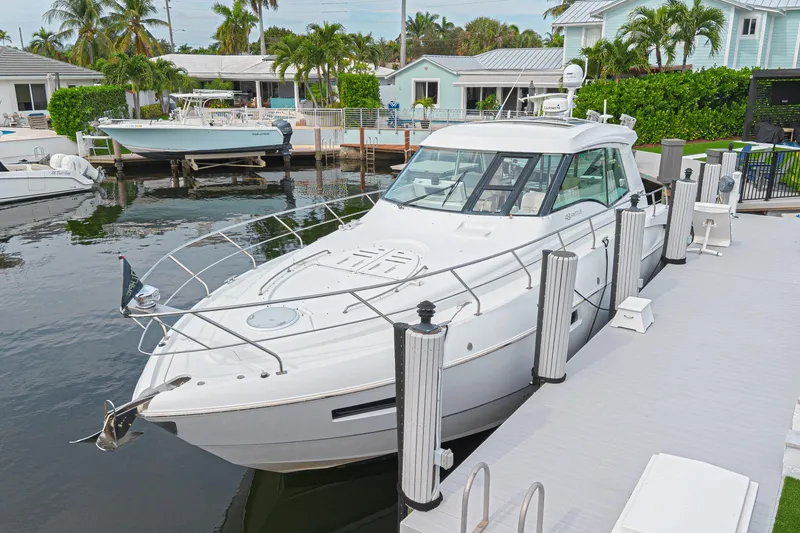 Slide: The Image of 2012 Cruisers Yachts 48 Cantius docked in a scenic marina setting. - 4