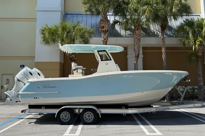 The Image of 2026 Pioneer 250 Pelagic boat on trailer, parked near palm trees. - 0
