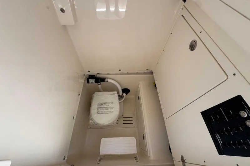 Slide: The Image of Interior of 2026 Pioneer 250 Pelagic boat, featuring a compact marine toilet setup. - 10