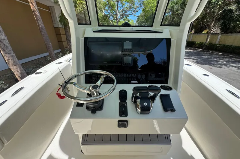 Slide: The Image of 2026 Pioneer 250 Pelagic boat dashboard with steering wheel and modern controls. - 11
