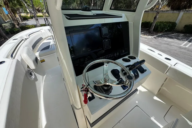Slide: The Image of 2026 Pioneer 250 Pelagic boat dashboard with steering wheel and navigation controls. - 12