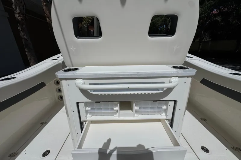 Slide: The Image of Interior view of 2026 Pioneer 250 Pelagic boat, featuring storage compartments and cup holders. - 14