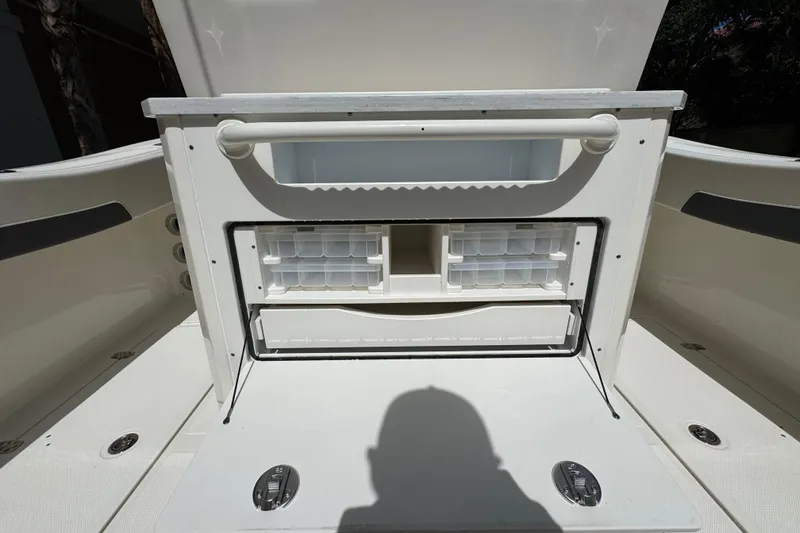 Slide: The Image of 2026 Pioneer 250 Pelagic boat storage compartment with organized tackle boxes and secure latches. - 15
