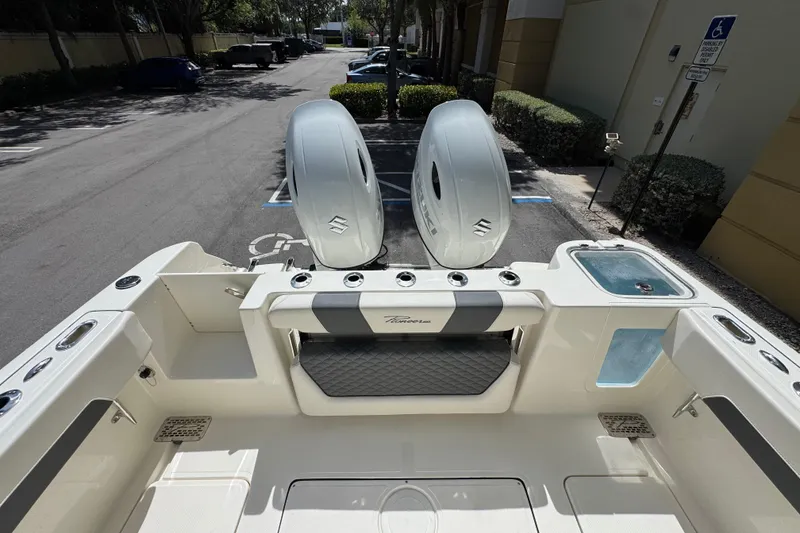 Slide: The Image of 2026 Pioneer 250 Pelagic boat with dual outboard engines in a parking lot. - 17