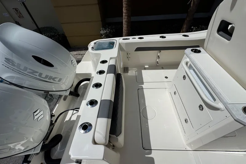 Slide: The Image of 2026 Pioneer 250 Pelagic boat interior with Suzuki engine, featuring rod holders and storage compartments. - 18