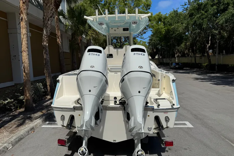 Slide: The Image of 2026 Pioneer 250 Pelagic boat with dual 150 horsepower engines, parked outdoors. - 3