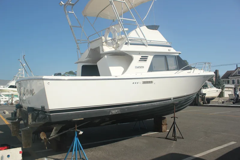 Slide: The Image of 1995 Blackfin 29 Flybridge boat on stands in a marina parking lot. - 2