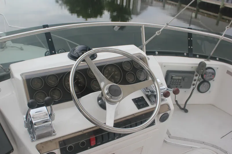Slide: The Image of 1995 Blackfin 29 Flybridge helm with steering wheel, gauges, and marine radio. - 8
