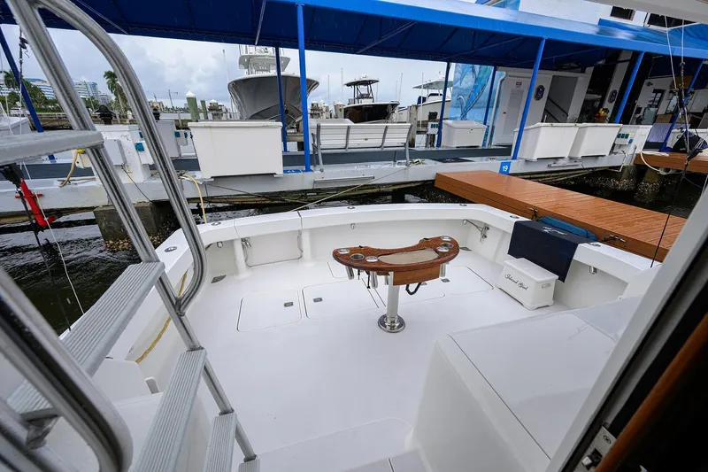 Slide: The Image of 2004 Viking 48 Convertible yacht docked, featuring spacious deck and fishing chair. - 70