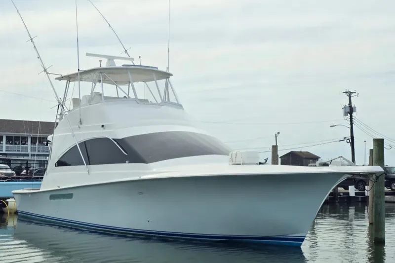 The Image of 2004 Ocean Yachts 50 Super Sport docked at a marina, showcasing sleek design and fishing equipment. - 0