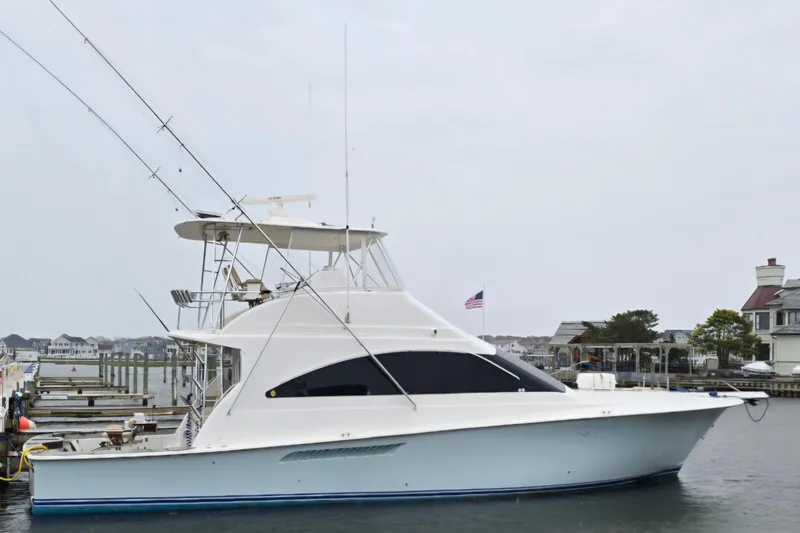 Slide: The Image of 2004 Ocean Yachts 50 Super Sport docked at a marina, showcasing sleek design and fishing equipment. - 1