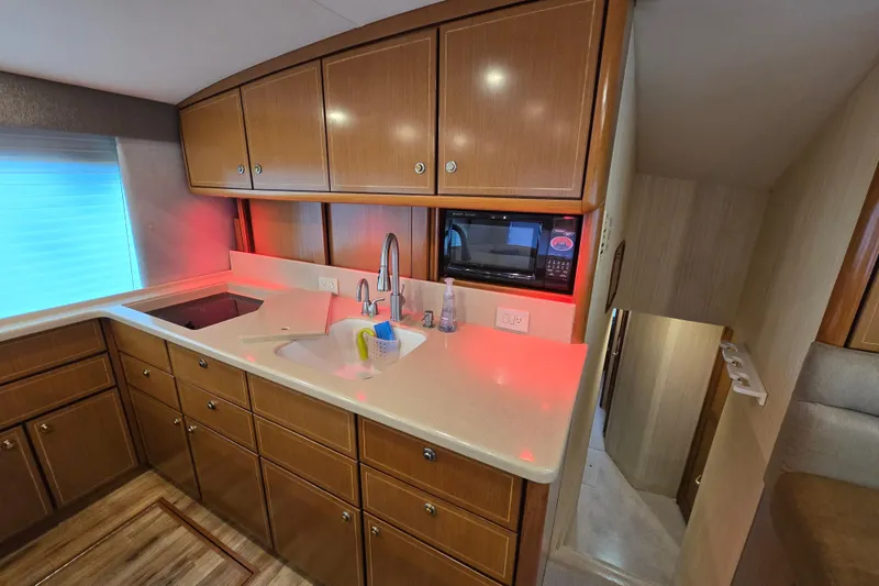 Slide: The Image of 2004 Ocean Yachts 50 Super Sport kitchen with wooden cabinets, sink, and microwave. - 15