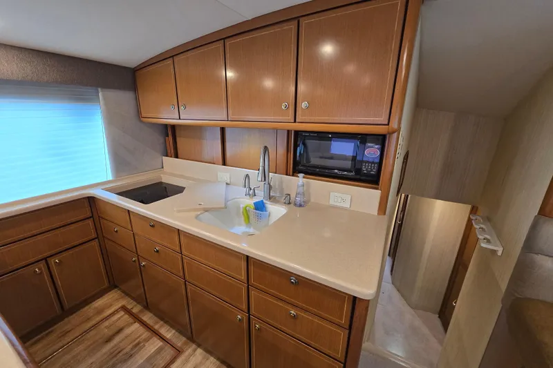Slide: The Image of Luxurious kitchen interior of 2004 Ocean Yachts 50 Super Sport with wood cabinetry. - 16