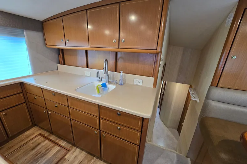 Slide: The Image of 2004 Ocean Yachts 50 Super Sport kitchen with wooden cabinets and modern sink. - 17